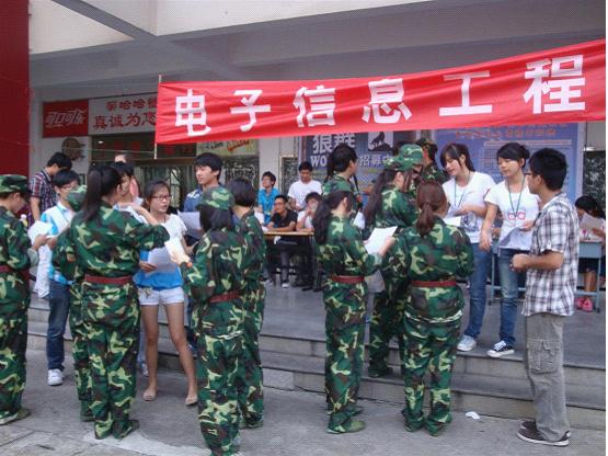 图为：电信系学生会各部门的助理们正向过往的学生发放招新宣传单