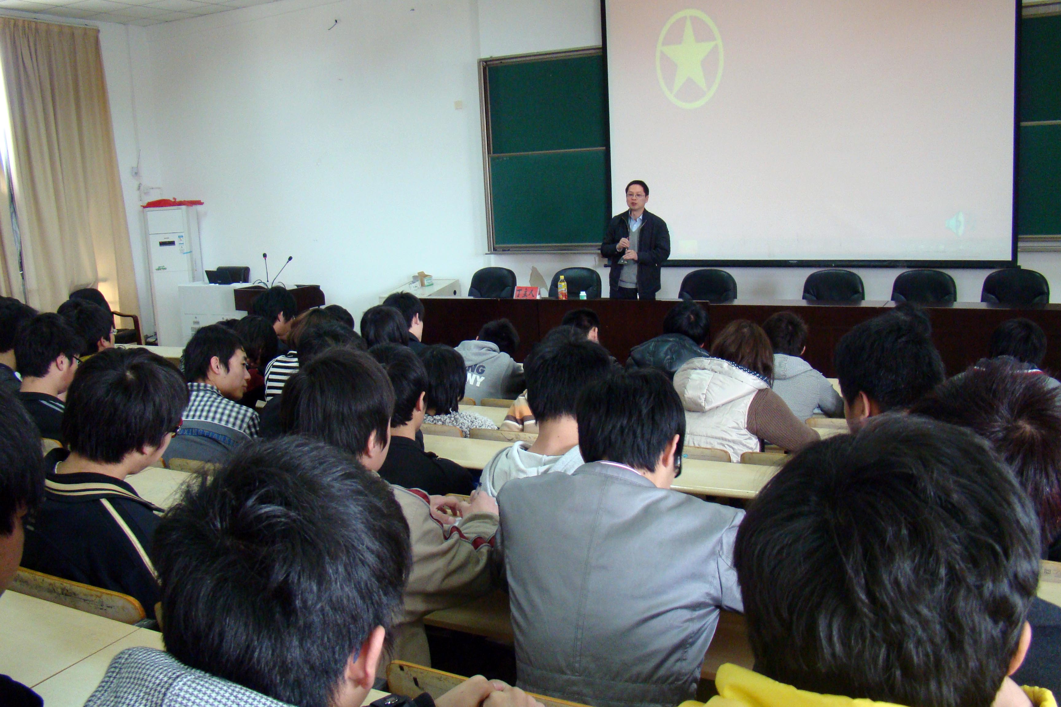 图为:丁老师站着在和学生交流