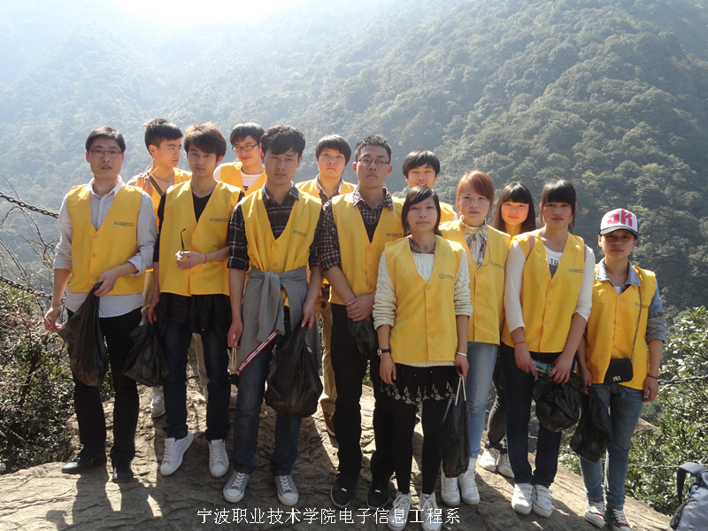 图为：志愿者们和老师在山顶的合影