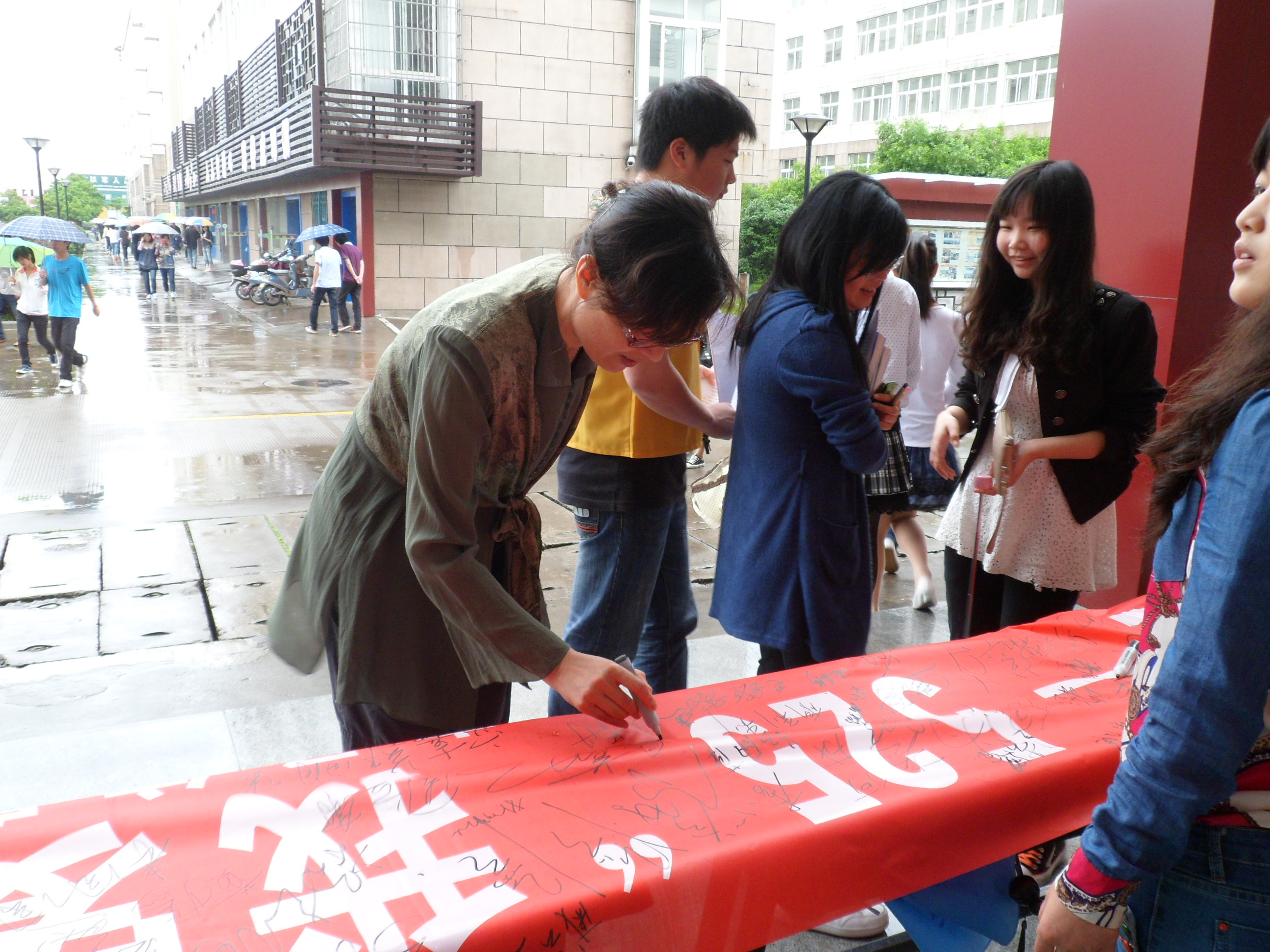 图为：老师在横幅上签名