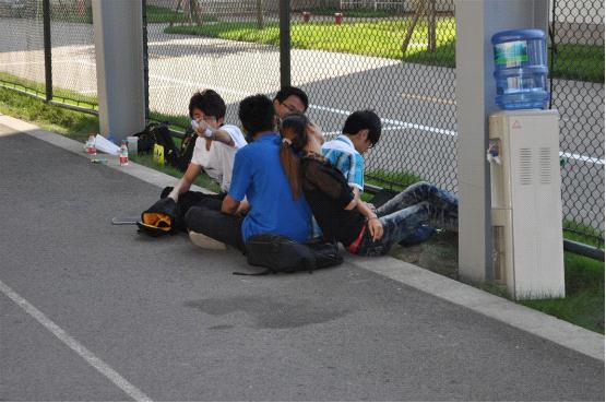 图为：两位班导累了，就相互之间靠着休息