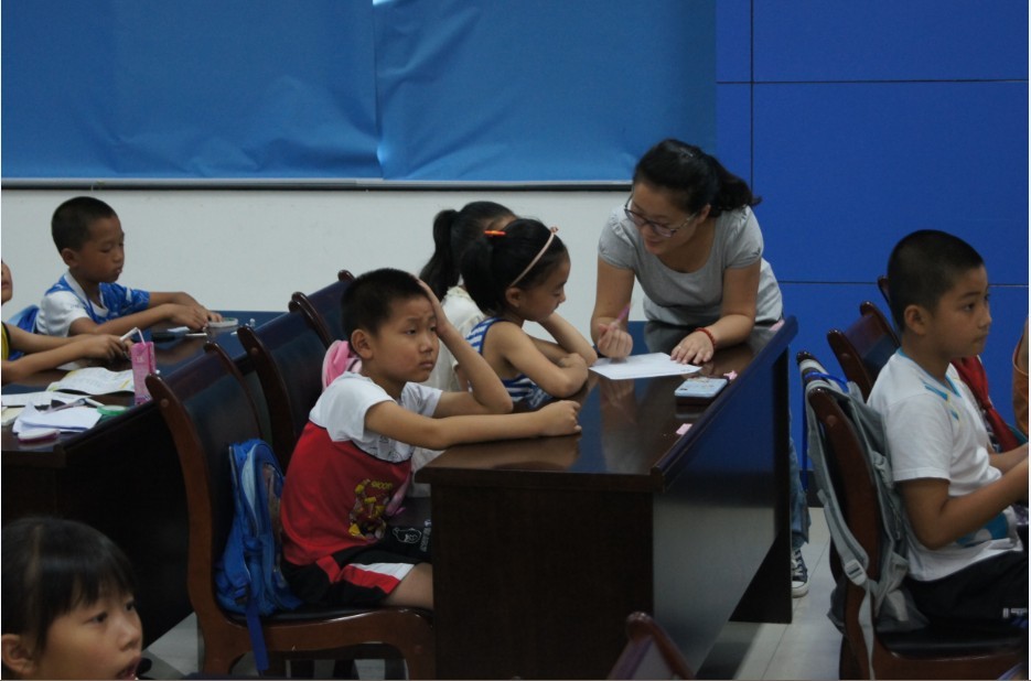 图为：志愿者指导小朋友的作业