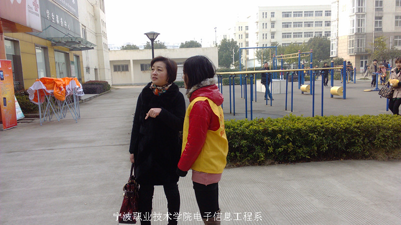 图为：志愿者为前来参加招聘会的人指路