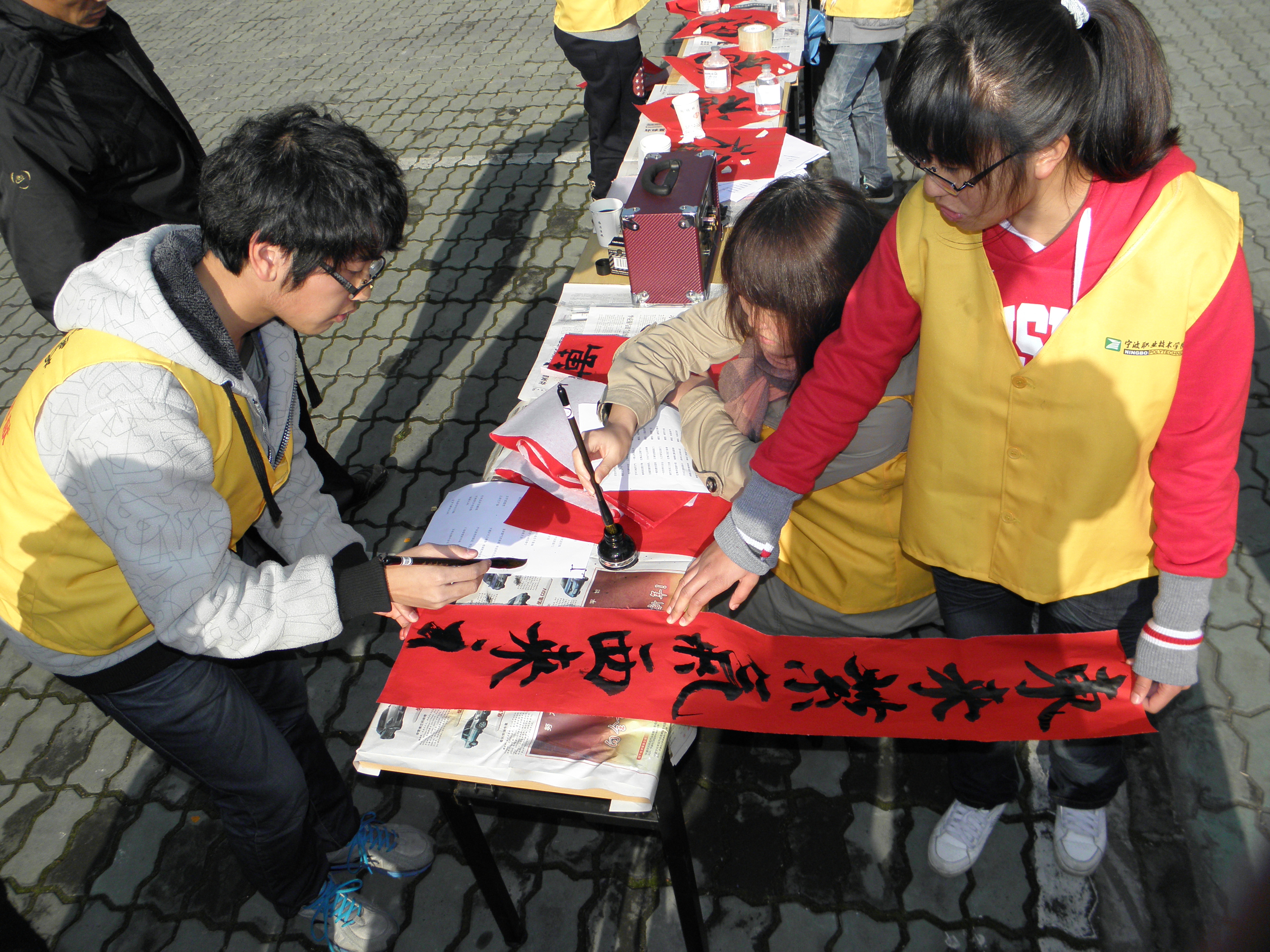 图为:电子系志愿者正在挥墨送福 图为:电子系志愿者正在挥墨送福