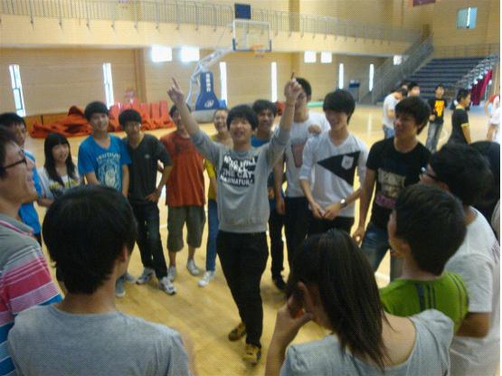 图为：游戏获胜队伍的队长高举“1”的手势