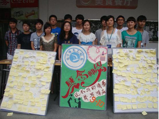 图为：所有电子信息工程系的同学在写满祝福语的KT板前合影