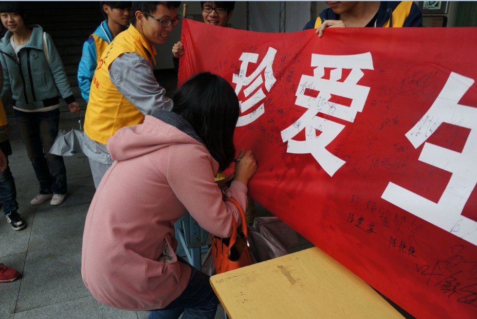 图为同学们签名响应本次宣传活动