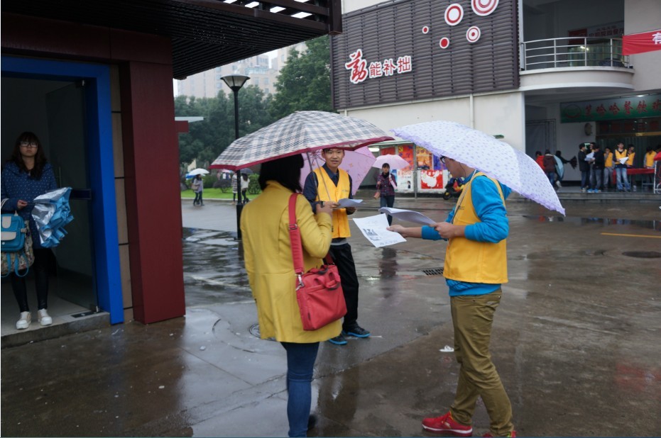 图为志愿者们在雨中发宣传单