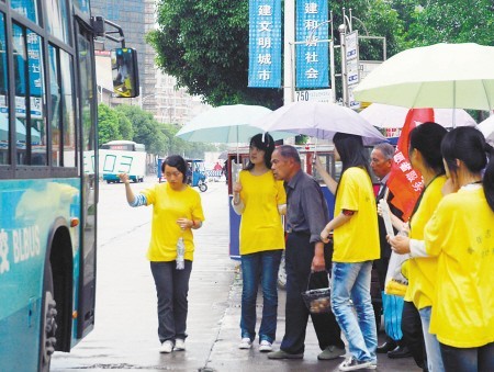 来自会计系的黄衫志愿者在公交车站维持秩序
